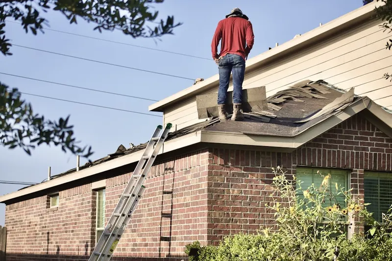 Professional roofer working on a residential roof in Country Club